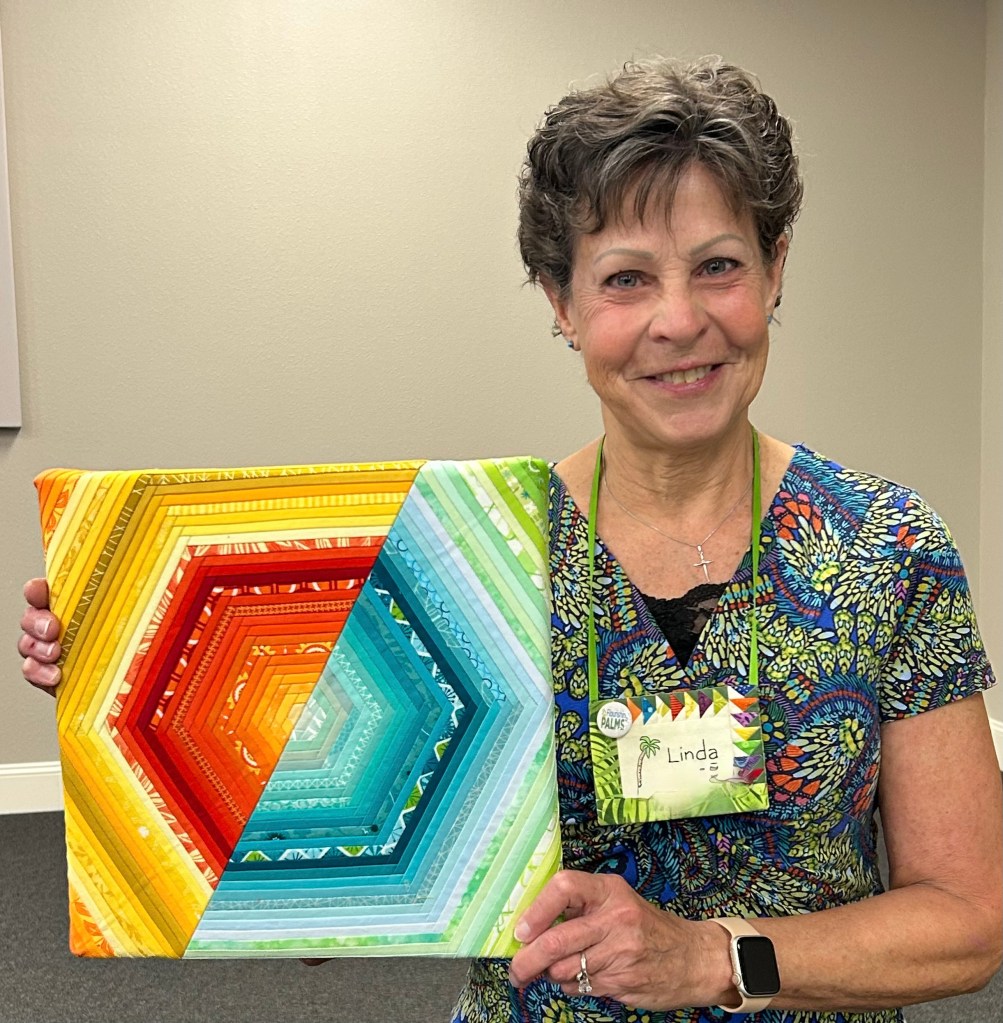 Linda H @flourishingpalms showed a 12" X 12" canvas mounted with Scrappy FPP Hexagon, a pattern by Cristina @shipsandviolins, being sold as a fundraiser for the Toronto MQG.